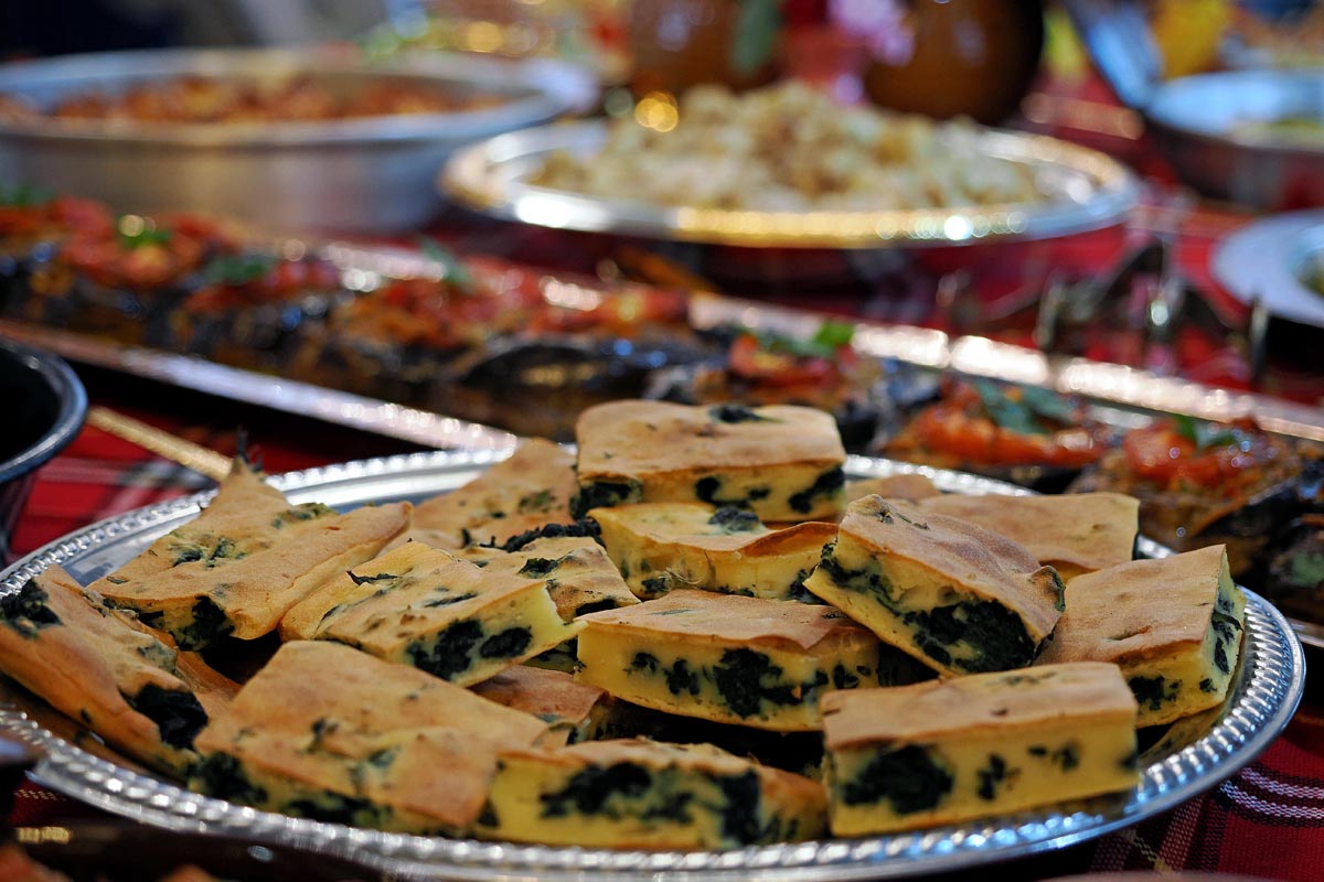 Narezani komadi domaće pite sa špinatom i sirom posluženi na ovalnom tanjuru