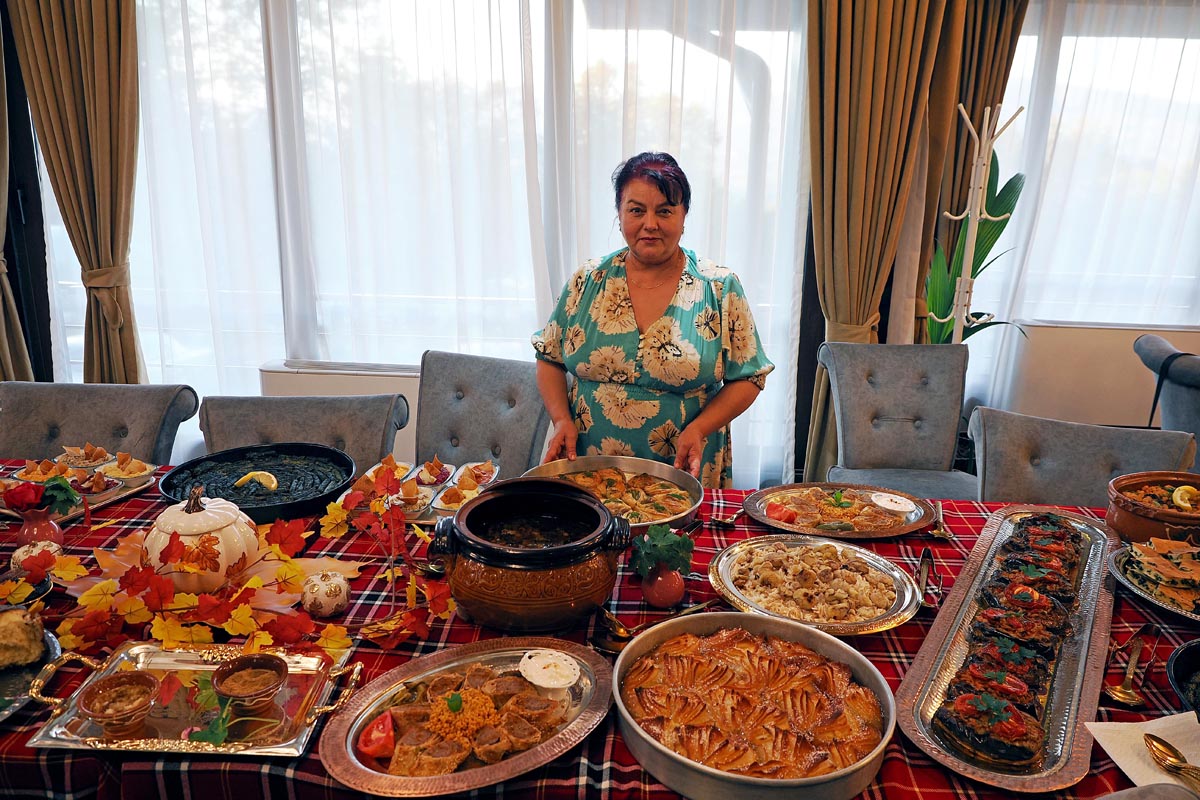 Zyumrud Tatlicheva stoji iza bogatog stola s tradicionalnim bugarskim jelima u Villi Vakanica